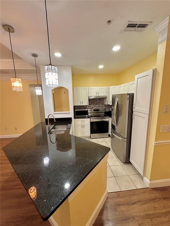 3280 Soho Street, Unit 308 Orlando, FL 32835 - Photo 12 of 45 a kitchen with a sink a counter top space appliances and cabinets