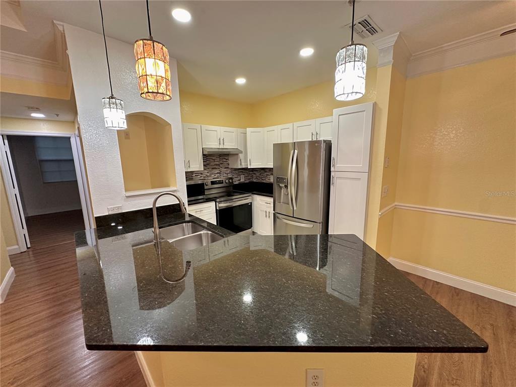 3280 Soho Street, Unit 308 Orlando, FL 32835 - Photo 15 of 45 a kitchen with stainless steel appliances granite countertop a sink a stove top oven a counter space and cabinets