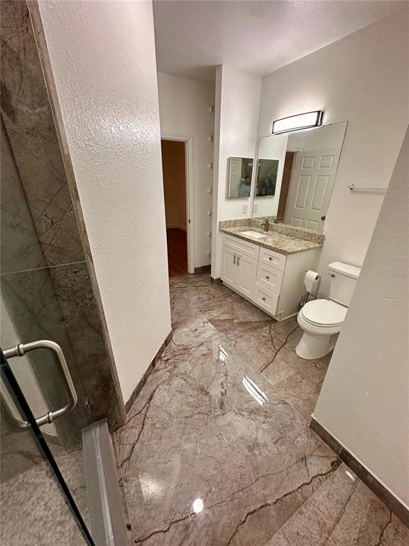 3280 Soho Street, Unit 308 Orlando, FL 32835 - Photo 24 of 45 a bathroom with a sink a toilet a mirror and shower