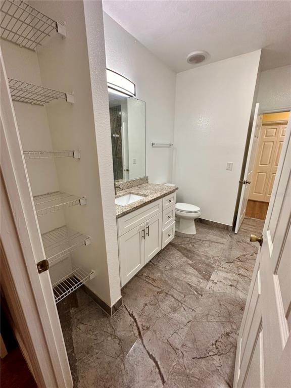 3280 Soho Street, Unit 308 Orlando, FL 32835 - Photo 27 of 45 a bathroom with a sink a toilet and a mirror