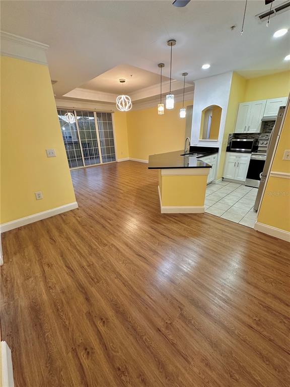 3280 Soho Street, Unit 308 Orlando, FL 32835 - Photo 10 of 45 a view of a kitchen with kitchen island granite countertop wooden floors and a sink