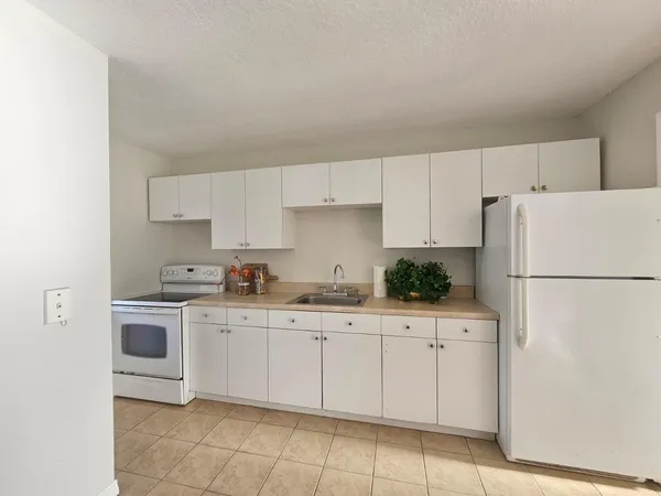 a kitchen with white cabinets and white appliances