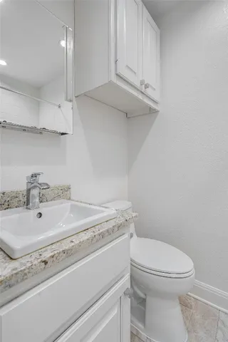 a bathroom with a sink a toilet and vanity