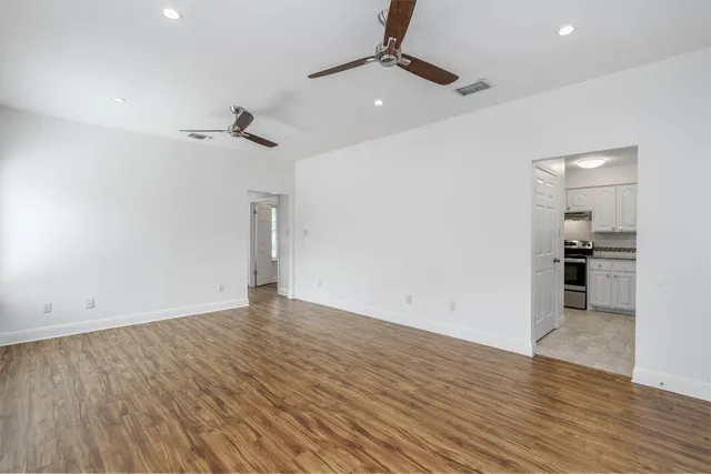 a view of empty room with wooden floor