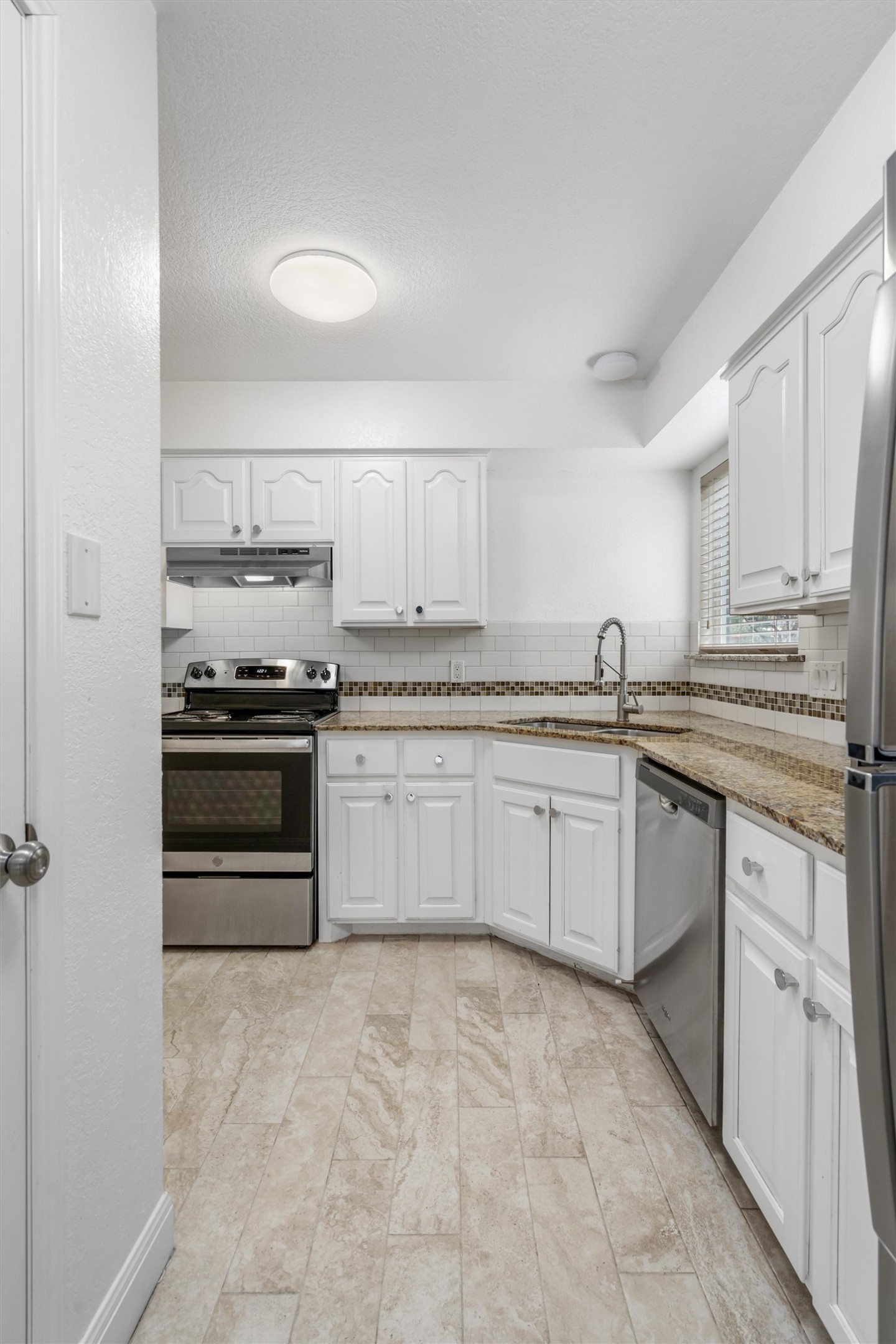 201 East 35th Street, Unit B Austin, TX 78705 - Photo 8 of 27 a kitchen with stainless steel appliances granite countertop a stove and white cabinets