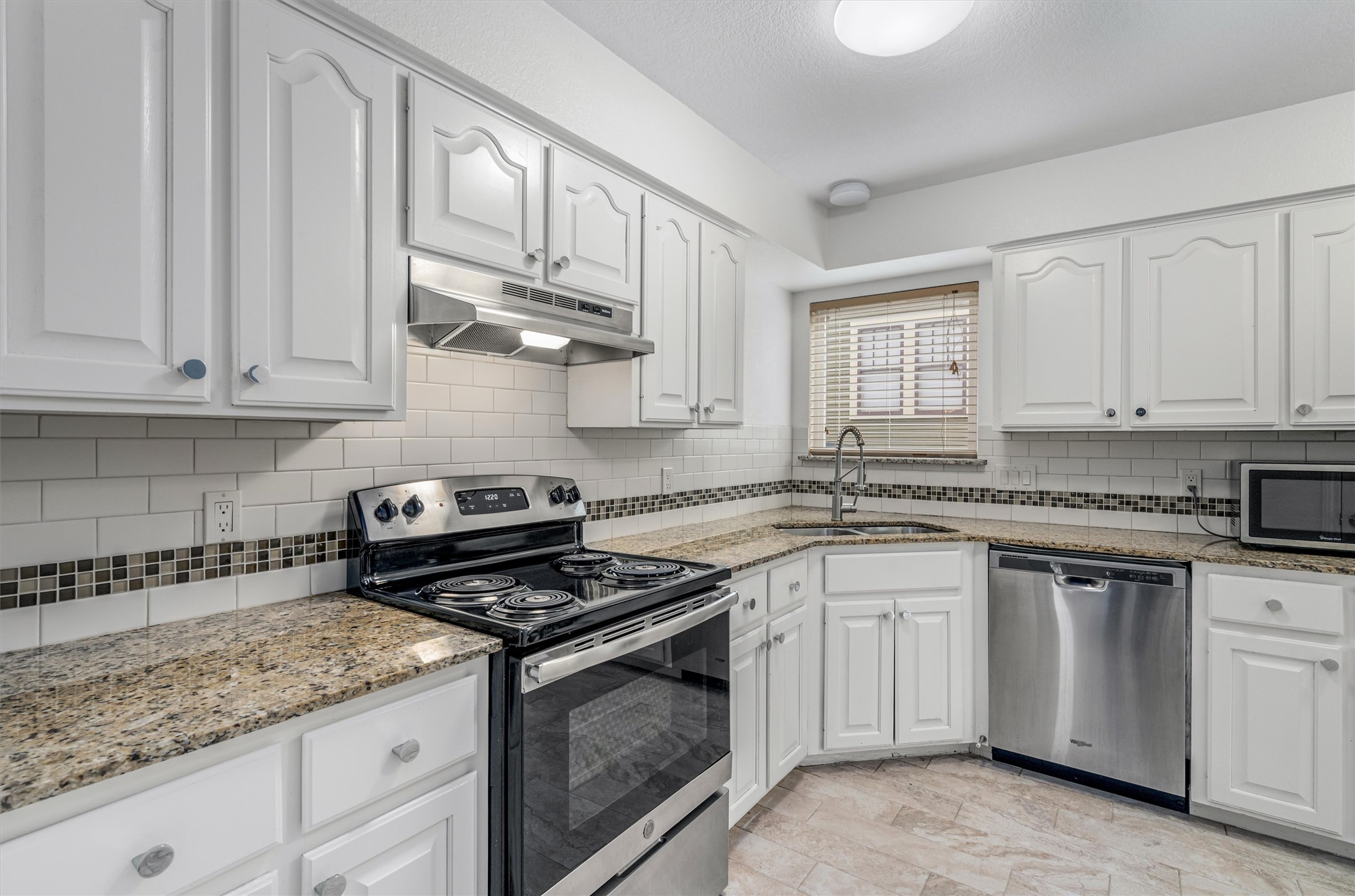 201 East 35th Street, Unit B Austin, TX 78705 - Photo 10 of 27 a kitchen with granite countertop white cabinets stainless steel appliances and a counter space