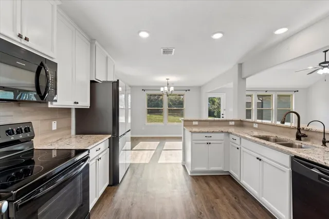 a kitchen with a sink stove top oven and refrigerator