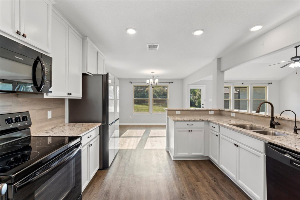 17855 Arbor Oaks Circle New Caney, TX 77357 - Photo 13 of 26 a kitchen with a sink stove top oven and refrigerator