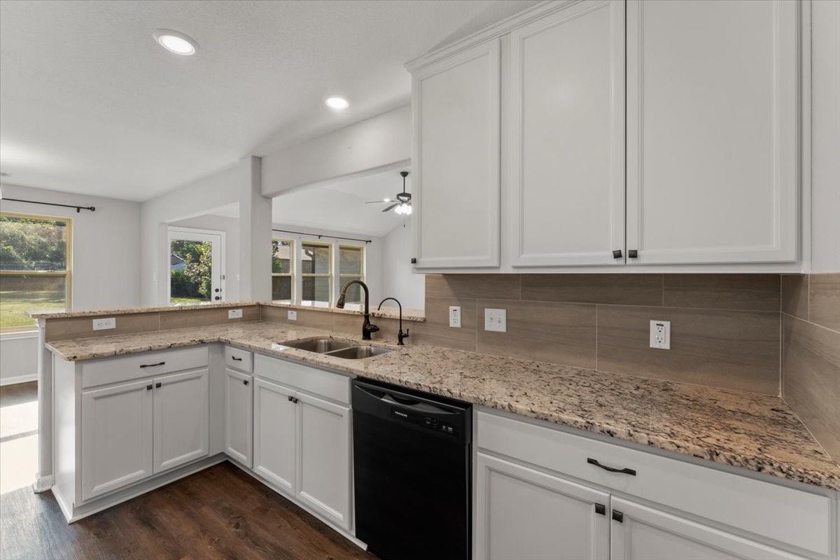17855 Arbor Oaks Circle New Caney, TX 77357 - Photo 15 of 26 a kitchen with a sink dishwasher and white cabinets with wooden floor