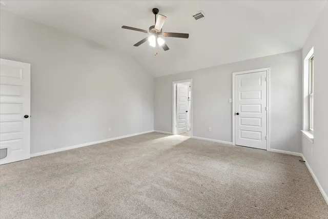 a view of an empty room with a ceiling fan