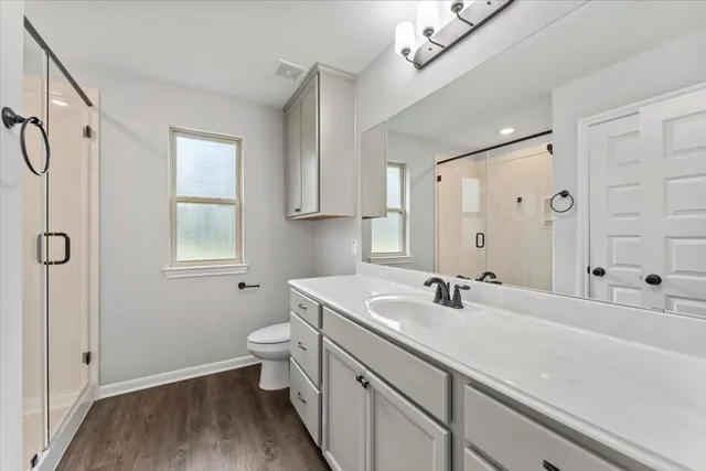 a bathroom with a sink a toilet and shower