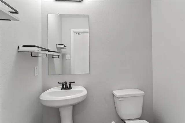 a bathroom with a toilet sink and mirror