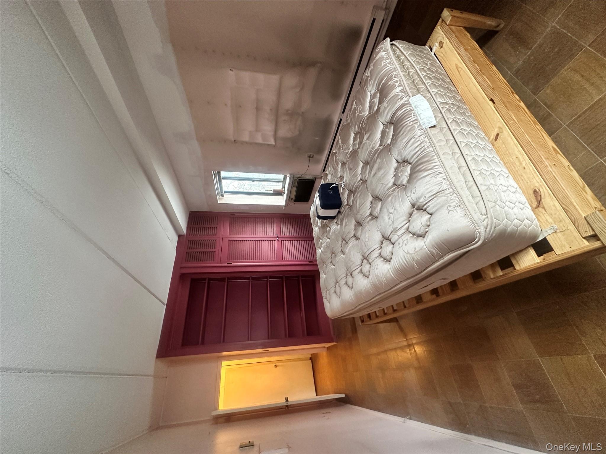 160 Academy Street, Unit L1 Poughkeepsie, NY 12601 - Photo 12 of 16 a bed sitting in a spacious bedroom next to a window and dresser