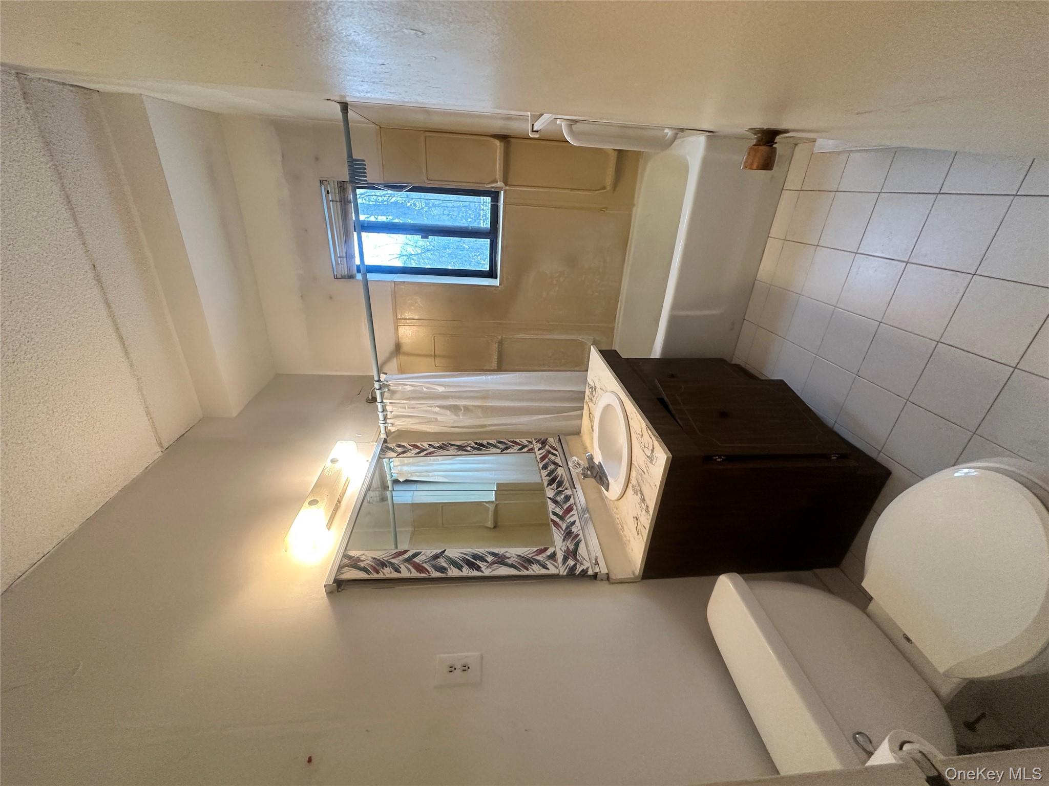 160 Academy Street, Unit L1 Poughkeepsie, NY 12601 - Photo 14 of 16 a bathroom with a granite countertop toilet sink and mirror