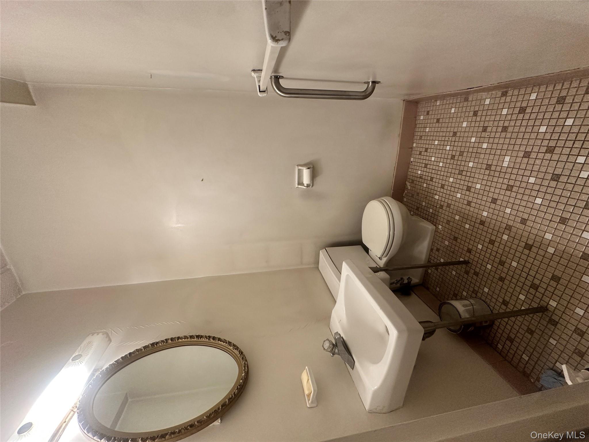 160 Academy Street, Unit L1 Poughkeepsie, NY 12601 - Photo 10 of 16 a bathroom with a sink a toilet and a mirror