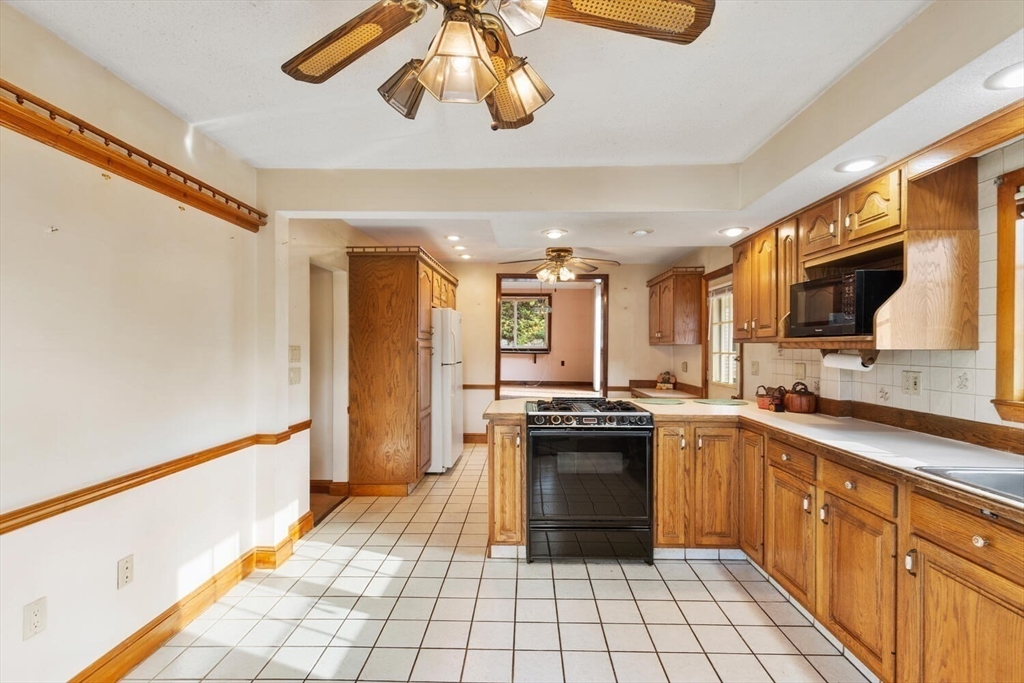 33 Springdale Avenue Saugus, MA 01906 - Photo 11 of 37 a kitchen with stainless steel appliances granite countertop a sink and cabinets