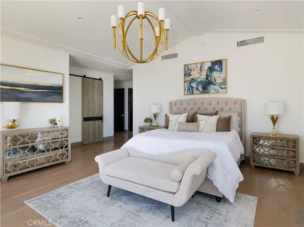 a spacious bedroom with a bed a mirror and dresser