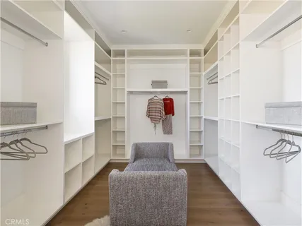 a view of walk in closet with clothes and shoes