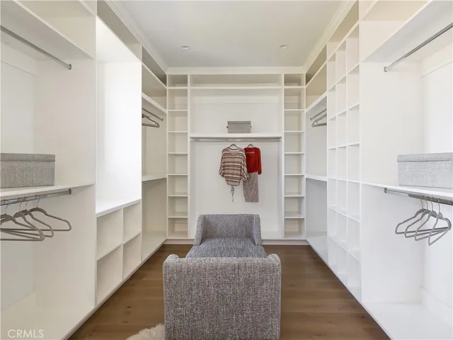 a view of walk in closet with clothes and shoes