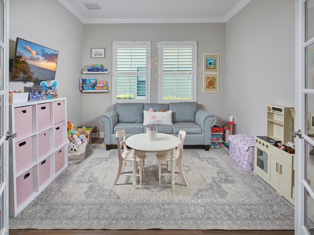 4613 Abaca Circle Naples, FL 34119 - Photo 23 of 36 a living room with furniture and a flat screen tv