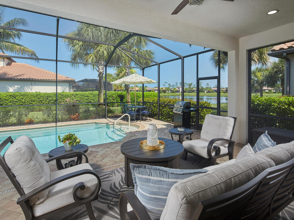 4613 Abaca Circle Naples, FL 34119 - Photo 3 of 36 a living room with patio furniture and a garden