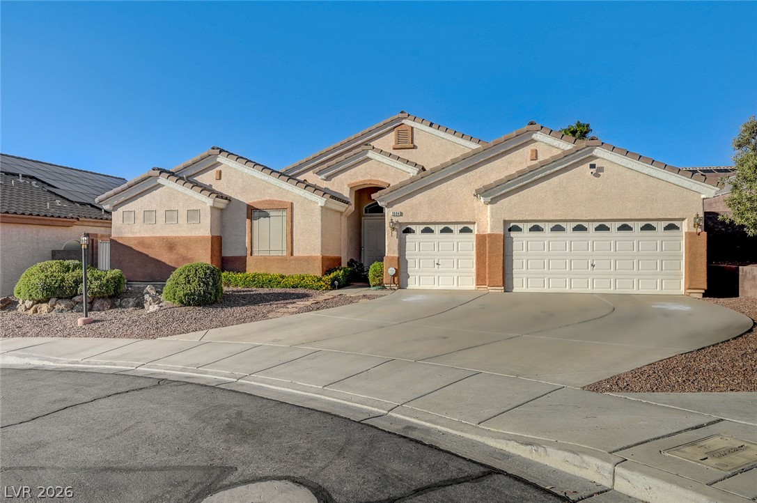 1604 Cattle Ranch Place Henderson, NV 89002 - Photo 9 of 99 A well-maintained stucco home with an attached garage and a neatly landscaped front yard.