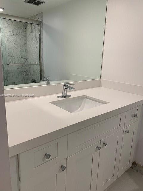 881 Ocean Drive, Unit TH11 Key Biscayne, FL 33149 - Photo 13 of 22 a bathroom with a sink and a mirror