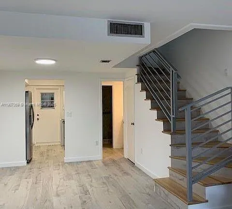 a view of entryway and gallery with wooden floor