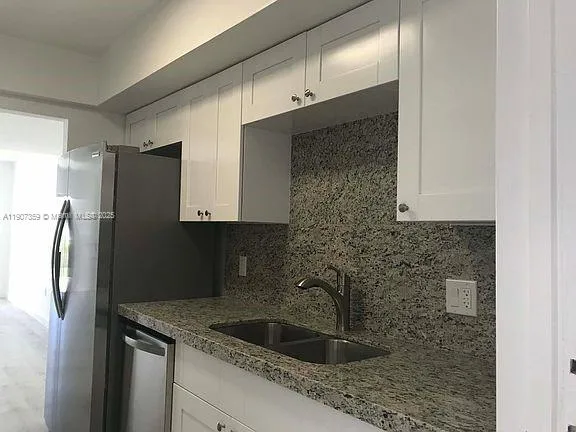 a kitchen with a sink and refrigerator