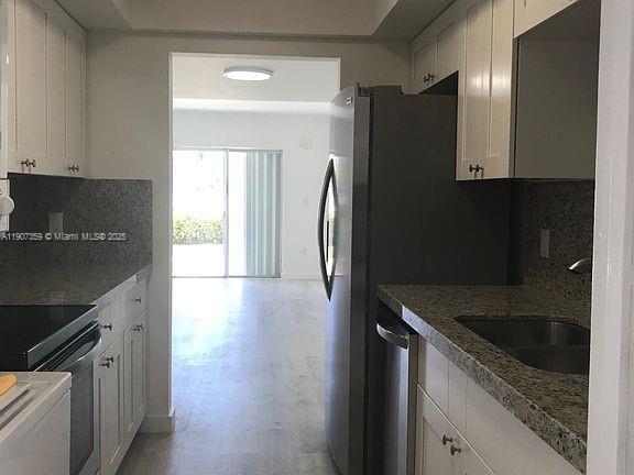 881 Ocean Drive, Unit TH11 Key Biscayne, FL 33149 - Photo 6 of 22 a kitchen with granite countertop a refrigerator and a sink