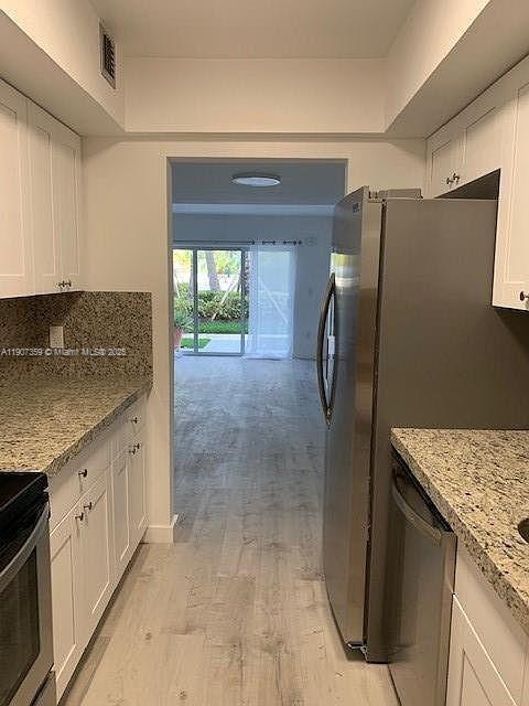 881 Ocean Drive, Unit TH11 Key Biscayne, FL 33149 - Photo 7 of 22 a kitchen with granite countertop a refrigerator and a sink