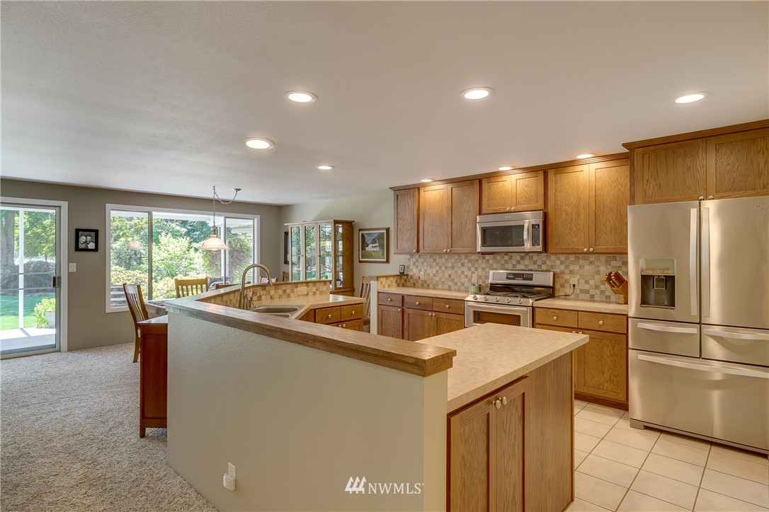 1118 Dyer Road Sultan, WA 98294 - Photo 12 of 40 a kitchen with stainless steel appliances granite countertop a sink and a refrigerator