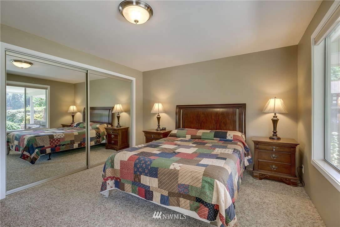 1118 Dyer Road Sultan, WA 98294 - Photo 23 of 40 a spacious bedroom with a bed and a lamp on table
