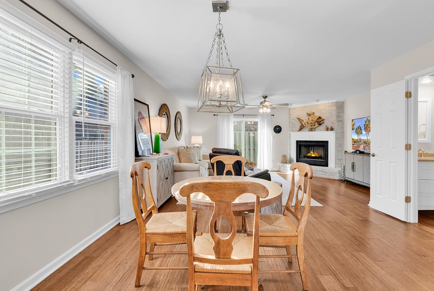 830 44th Avenue North, Unit L1 Myrtle Beach, SC 29577 - Photo 11 of 40 Dining room with a chandelier, a brick fireplace, light wood-style flooring, and a ceiling fan