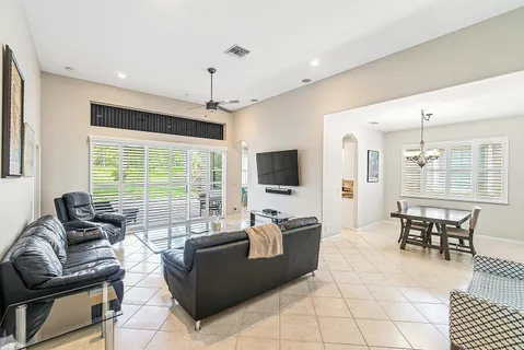 a living room with furniture a flat screen tv and a large window