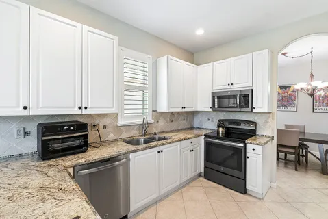 a kitchen with stainless steel appliances granite countertop a stove sink and cabinets