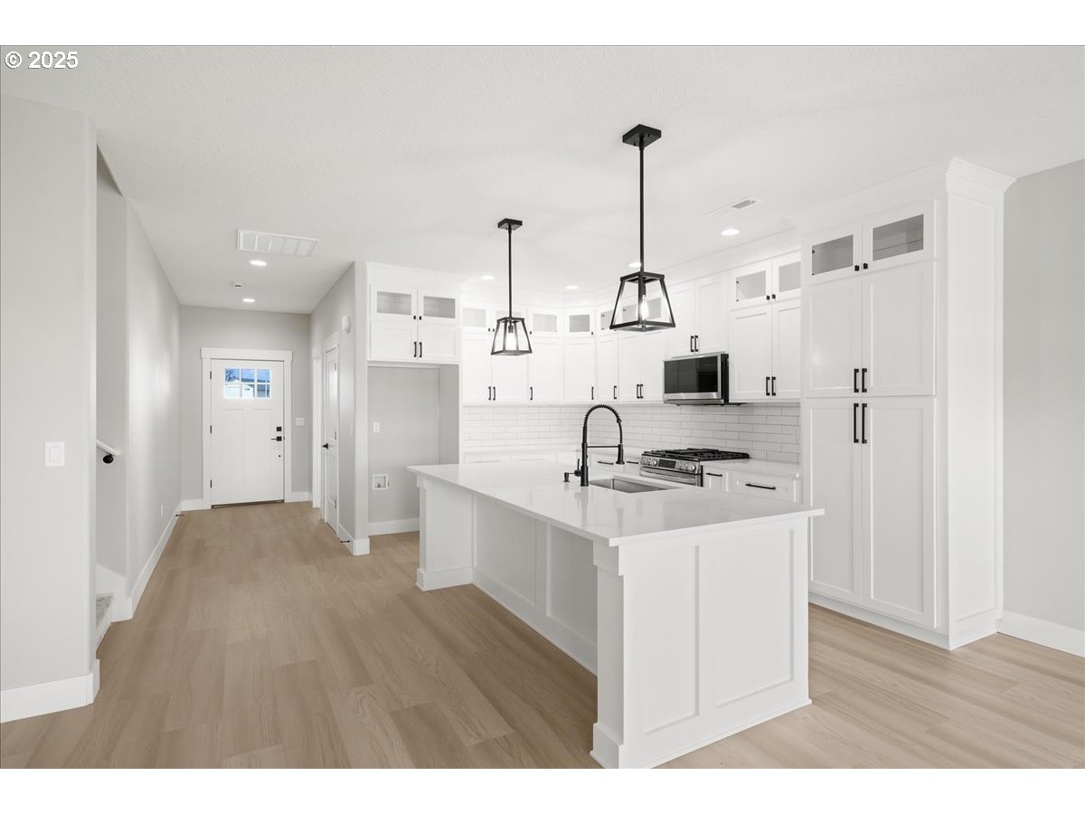 628 Parker Loop Silverton, OR 97381 - Photo 4 of 19 a kitchen with stainless steel appliances kitchen island a sink stove and refrigerator