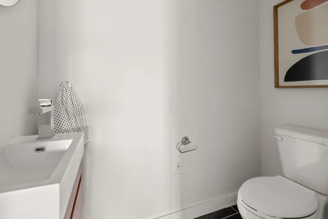 a white toilet sitting next to a bathroom sink