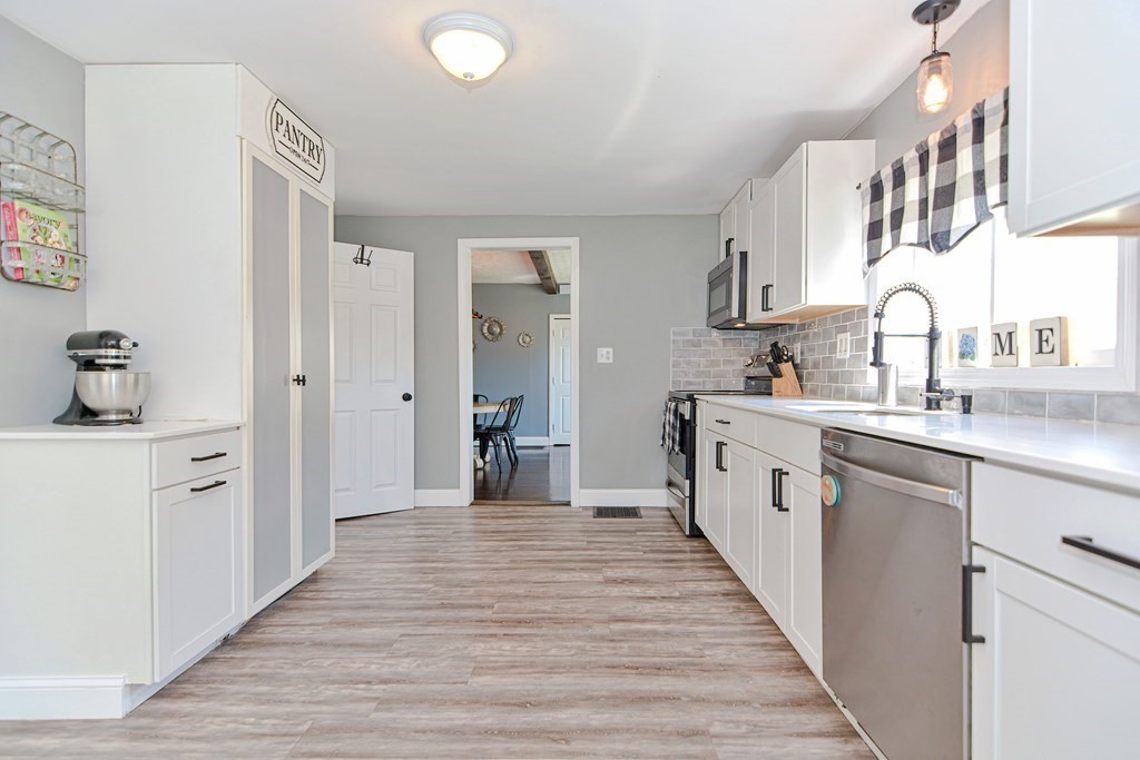 122 Mendon Road Sutton, MA 01590 - Photo 7 of 36 a kitchen with stainless steel appliances a sink and cabinets