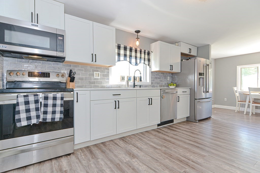 122 Mendon Road Sutton, MA 01590 - Photo 8 of 36 a kitchen with stainless steel appliances granite countertop a stove and white cabinets
