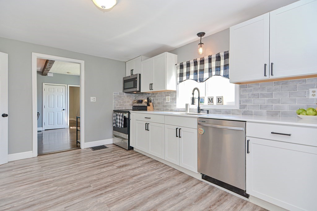 122 Mendon Road Sutton, MA 01590 - Photo 9 of 36 a kitchen with a sink cabinets and wooden floor