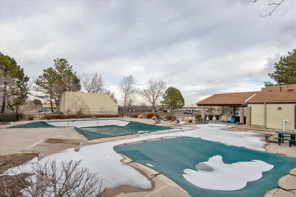 a swimming pool with outdoor seating and barbeque oven