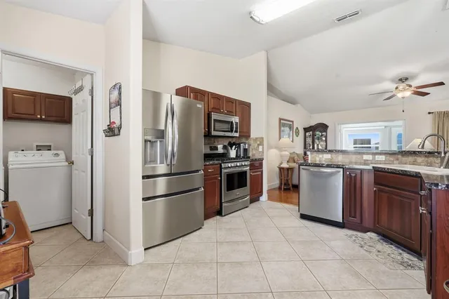 a kitchen with stainless steel appliances granite countertop a refrigerator and a sink