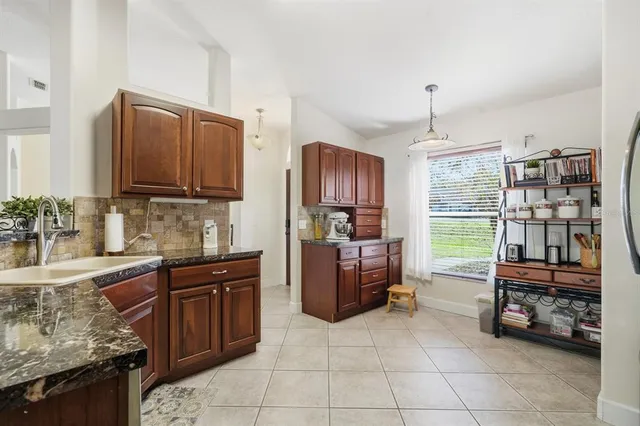 a kitchen with granite countertop a refrigerator and a stove top oven