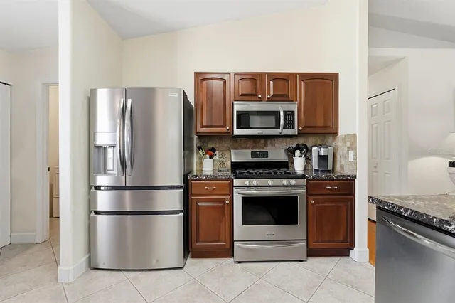 a kitchen with stainless steel appliances granite countertop a stove microwave and refrigerator