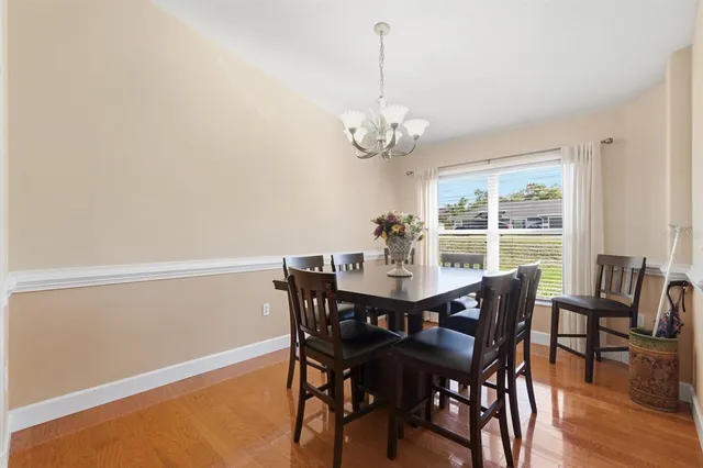 a view of a dining room with furniture a chandelier and wooden floor