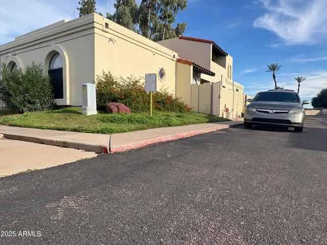 a view of a house with backyard and parking