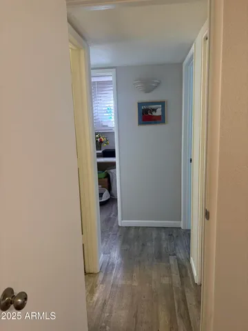 a view of a hallway with wooden floor and closet