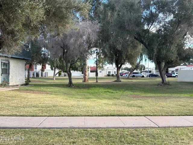 a view of a brick house with a small yard and wooden fence