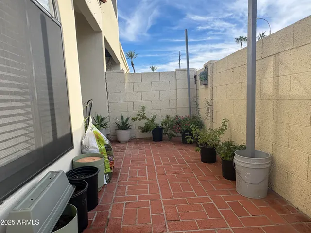 a view of a balcony with chairs potted plants